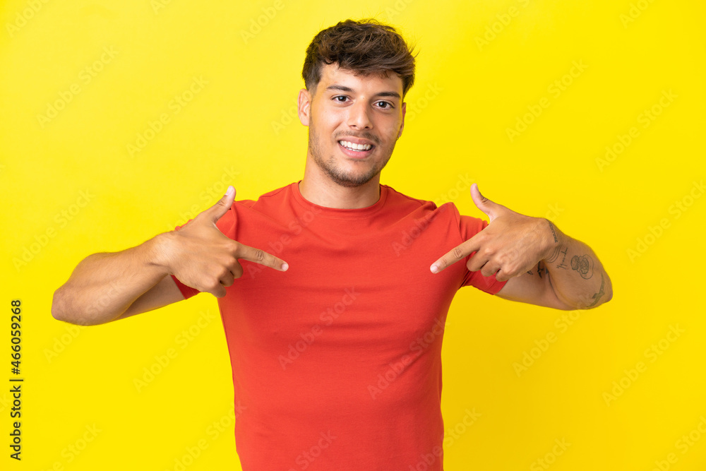 Young caucasian handsome man isolated on yellow background proud and self-satisfied Young caucasian handsome man isolated on yellow background proud and self-satisfied