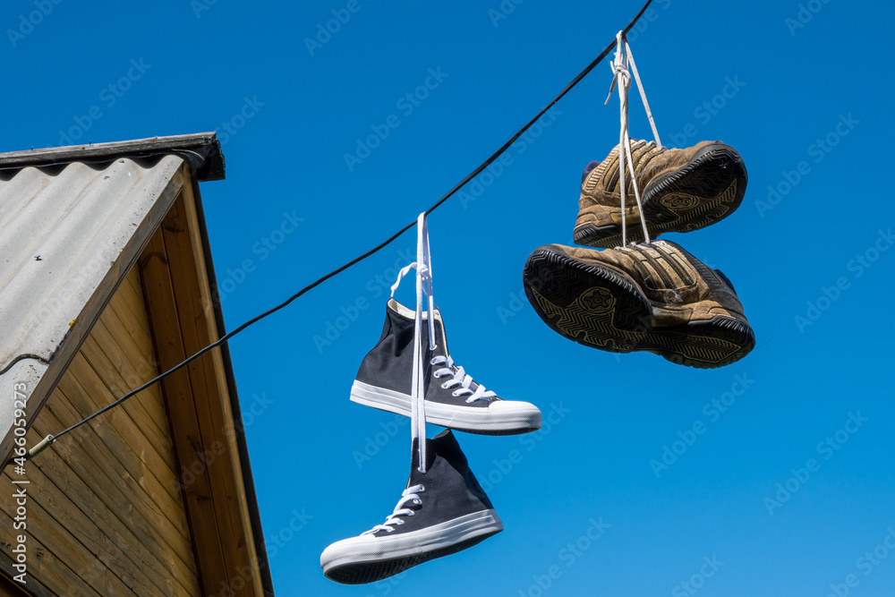 Sneakers hanging on electric wires. Stock Photo | Adobe Stock