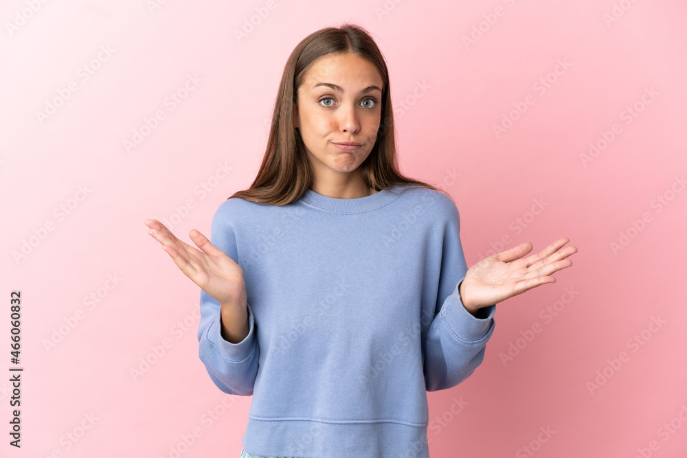 Young woman over isolated pink background making doubts gesture Young woman over isolated pink background making doubts gesture