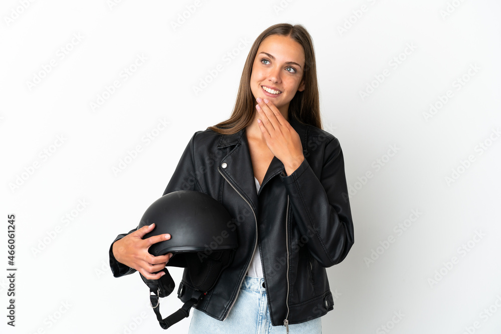 Woman with a motorcycle helmet over isolated white background looking up while smiling Woman with a motorcycle helmet over isolated white background looking up while smiling