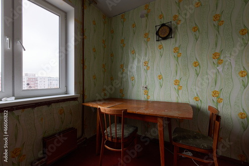 Example of Old Soviet Russian poor interior in Leningrad project House. Aged  sideboard, table, chairs, bed. Shabby floor. Tattered wallpaper on the wall. Apartment of pensioners. Selective focus.