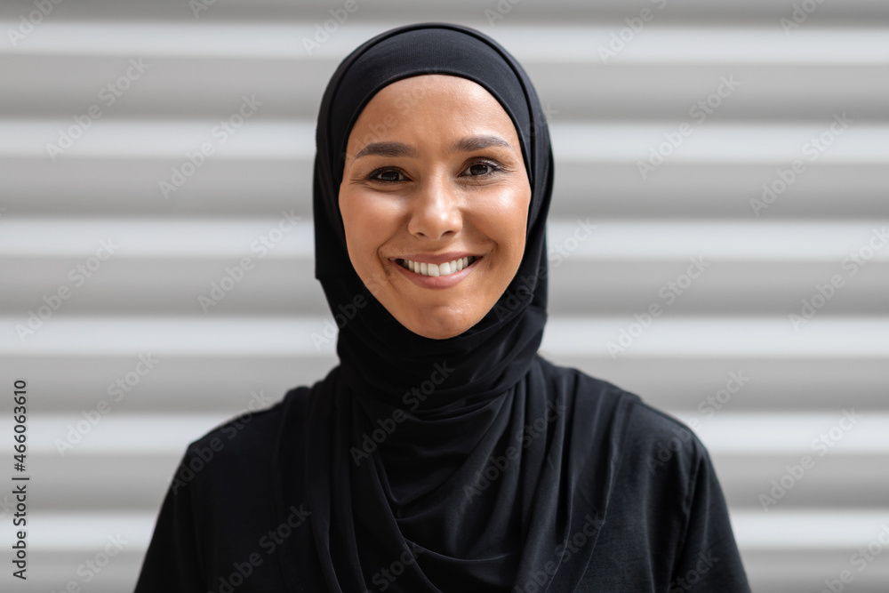 Portrait Of Smiling Young Arabic Woman Wearing Black Hijab Posing Outdoors Portrait Of Smiling Young Arabic Woman Wearing Black Hijab Posing Outdoors