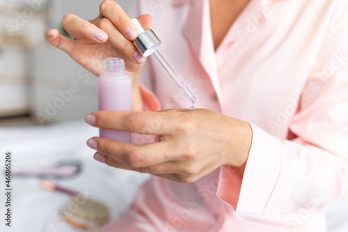Cropped close up of woman holding bottle of serum