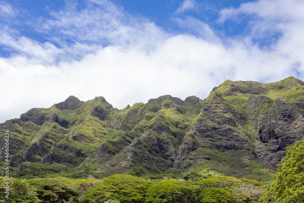 High mountain range covered in green plants with blue cloudy sky, Hawaii