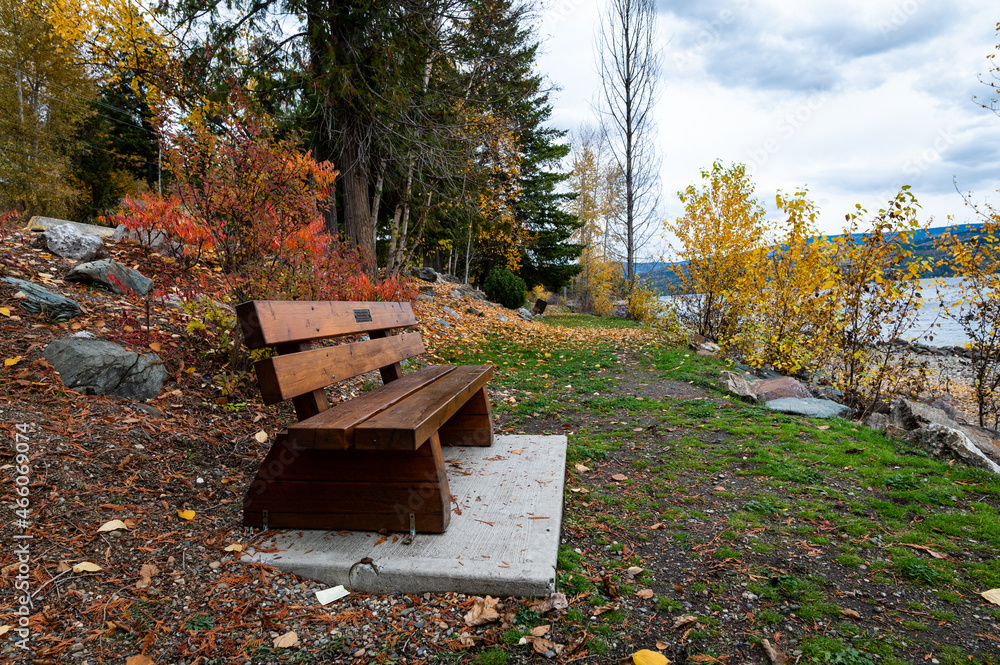 Photo of a wooden park bench facing towards Shuswap Lake in British Columbia Canada. Photo of a wooden park bench facing towards Shuswap Lake in British Columbia Canada.
