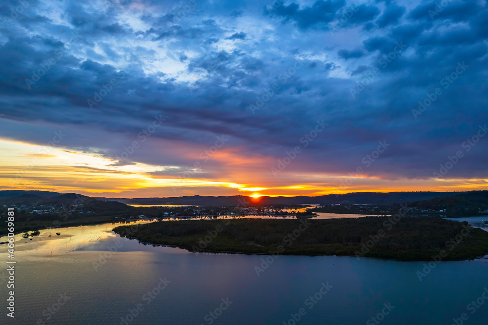 Fototapeta premium Sunrise waterscape with colourful cloud covered sky
