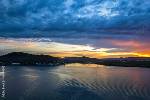 Sunrise waterscape with colourful cloud covered sky