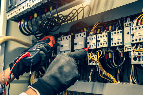 Electricity and electrical maintenance service, Close-up circuit breaker has engineer using measuring equipment checking electric volt at terminal block and cable wiring main power distribution board.