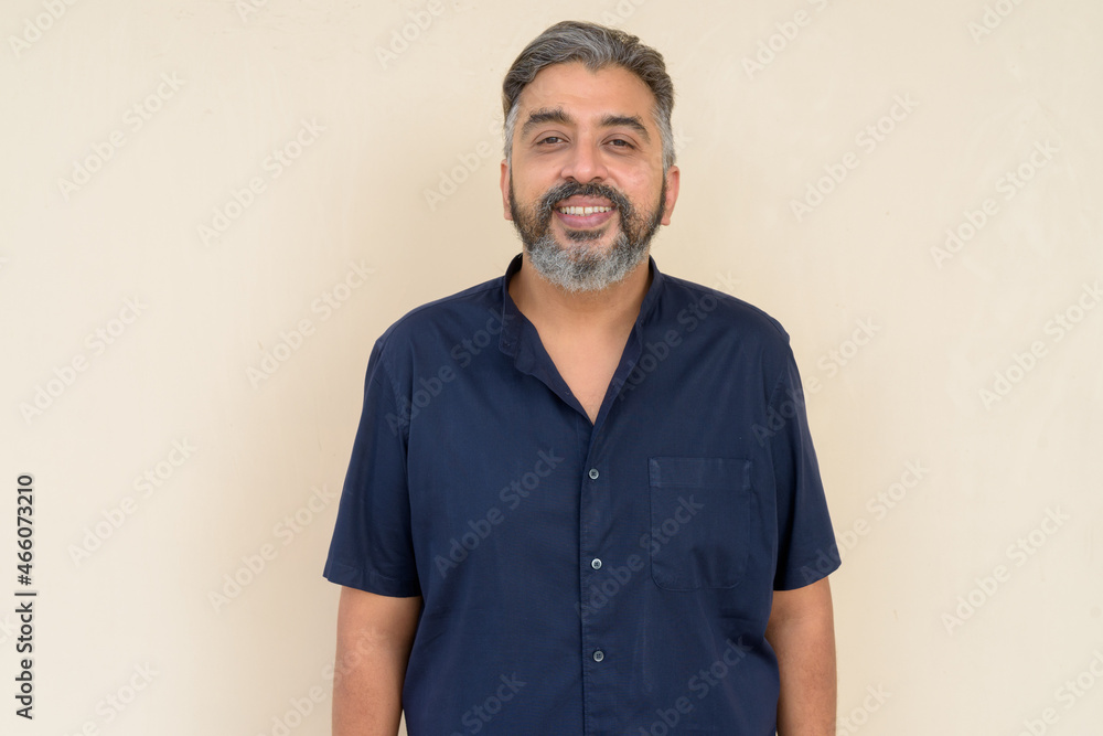 Portrait of bearded Indian businessman against plain background Portrait of bearded Indian businessman against plain background