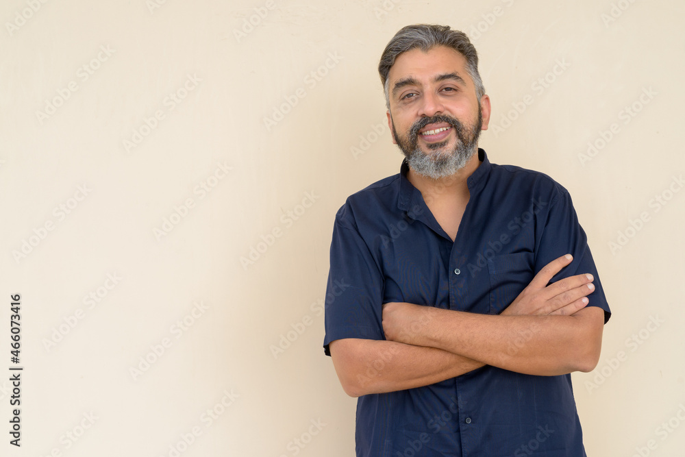 Portrait of bearded Indian businessman against plain background Portrait of bearded Indian businessman against plain background