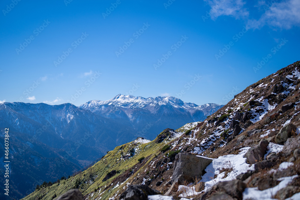 霞沢岳、乗鞍岳、上高地、穂高岳などを見るために、長野県松本市の晩秋の雪が積もる焼岳を登山する風景 Scenery of climbing Mt. Yakedake with snow in late autumn in Matsumoto, Nagano Prefecture to see Mt. Kasumisawa, Mt. Norikura, Kamikochi and Mt. Hodaka