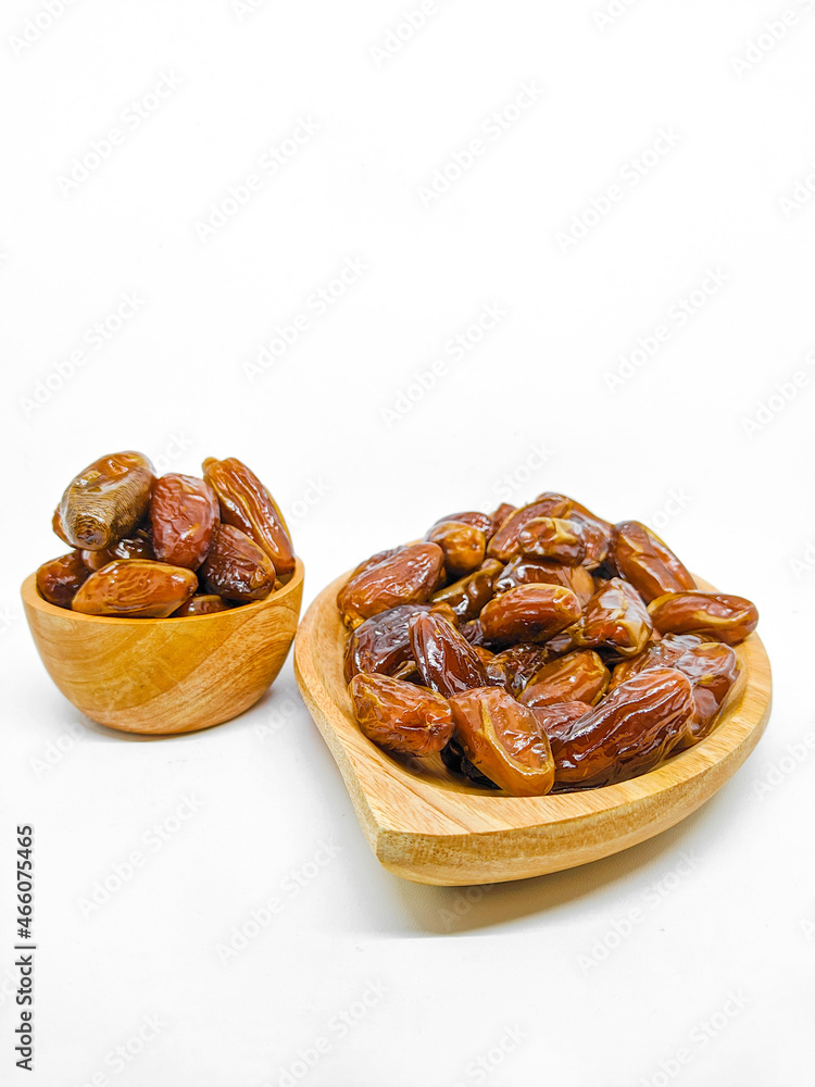 Fresh and healty premium honey tunisia dates (kurma tunisia) in a wooden bowl isolated on white background Fresh and healty premium honey tunisia dates (kurma tunisia) in a wooden bowl isolated on white background