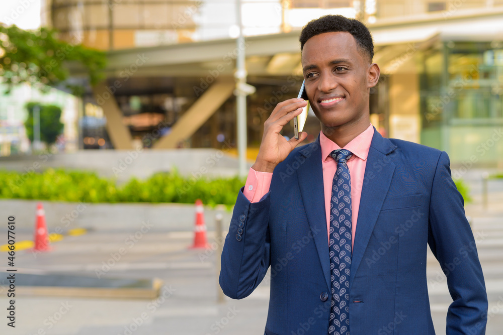 African businessman wearing suit and tie while using mobile phone African businessman wearing suit and tie while using mobile phone