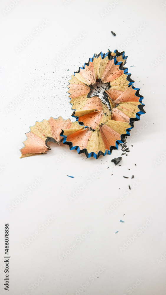 Close-up off blue-black colored pencil shavings on white background