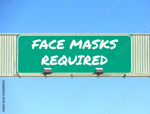 Face Masks Required road sign. Blue sky background.