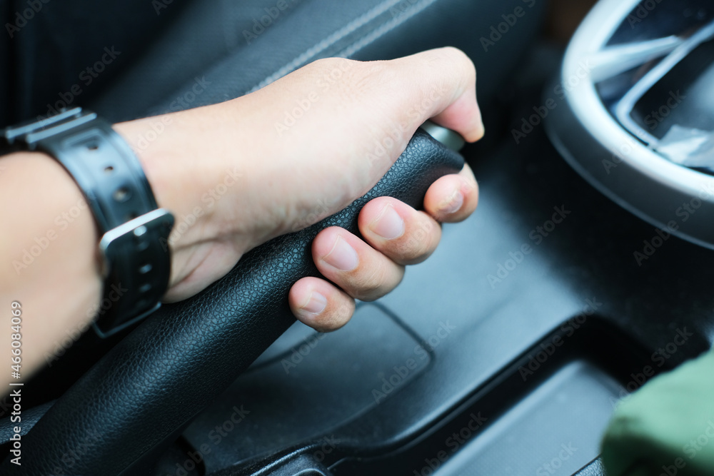 Person hand pulling the car handbreak lever
