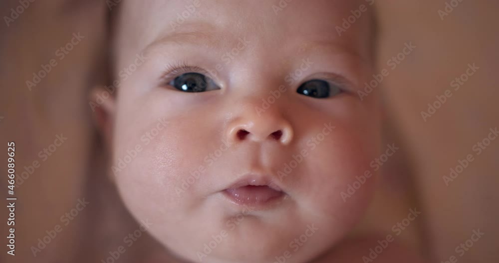 Beautiful baby with gray eyes lies on the bed. Close-up. Small child Beautiful baby with gray eyes lies on the bed. Close-up. Small child