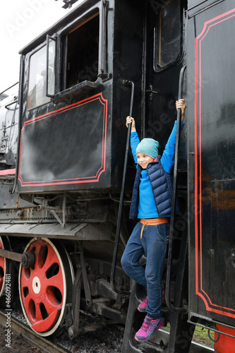 Boy on step of steam locomotive
