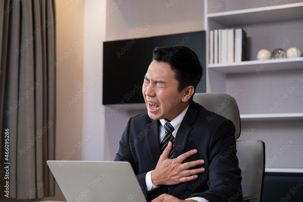 Adult men business person feeling painful from chest or heart attack while working, online meeting in front of the computer inside of the office area. Office syndrome, over working illness. Adult men business person feeling painful from chest or heart attack while working, online meeting in front of the computer inside of the office area. Office syndrome, over working illness.