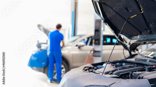 Mechanic working on checking and service car in workshop garage, engine oil change