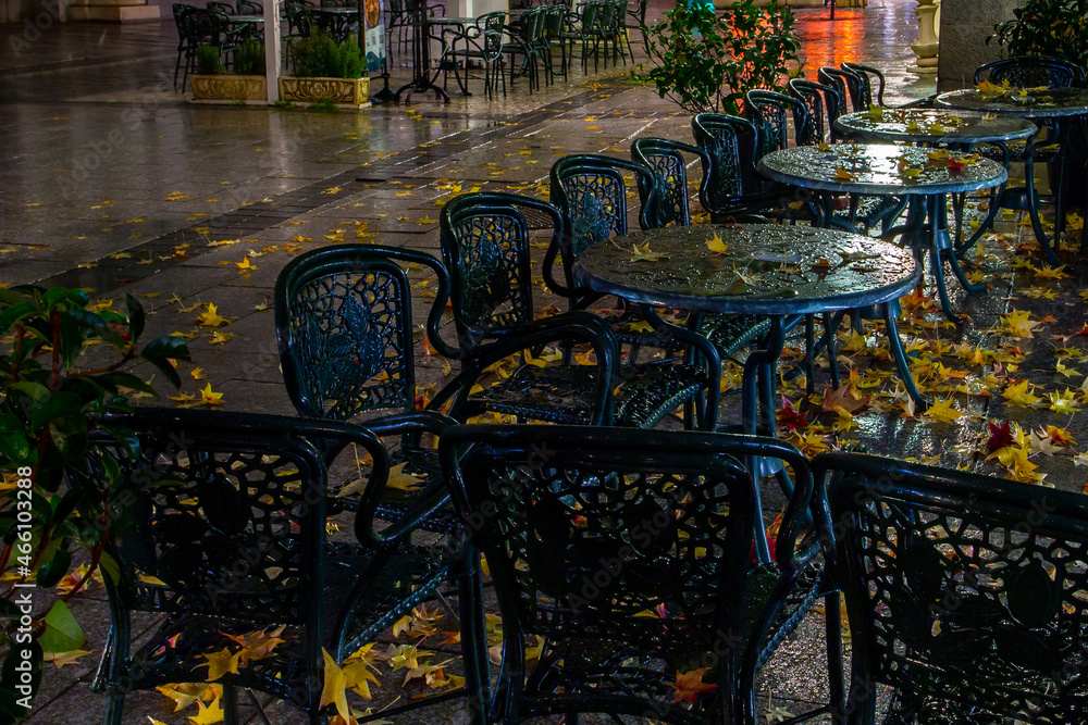 Autumn landscape with the leaves on the terraces of the restaurants. Night photo. Plaza de Oriente in autumn