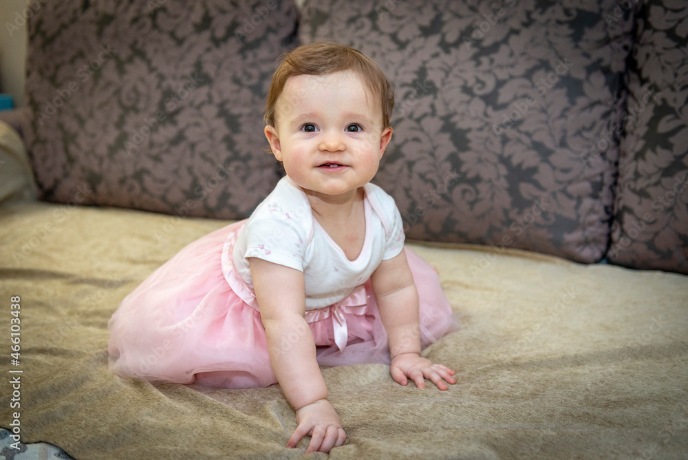 little girl on the couch in a pink skirt little girl on the couch in a pink skirt