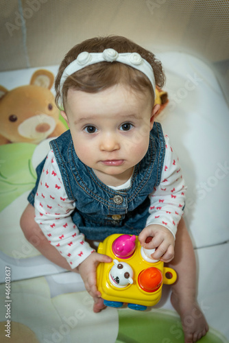 a little baby girl is sitting in an aviary with toys