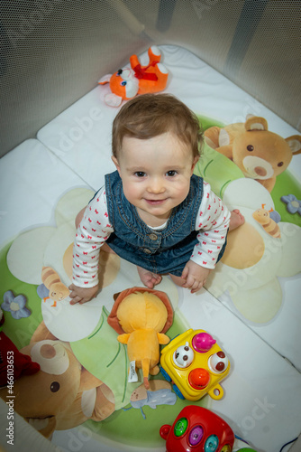 a little baby girl is sitting in an aviary with toys
