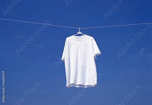 White Shirt Hanging on a Clothesline Against a Blue Sky