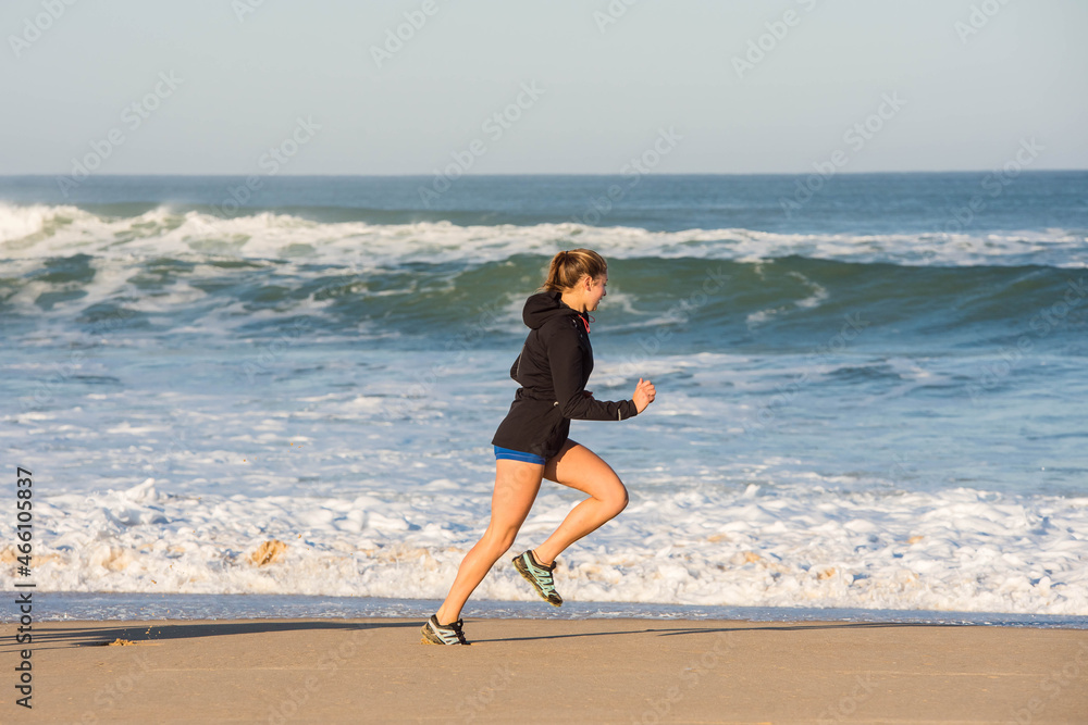 beautiful young athletic woman running on the beach