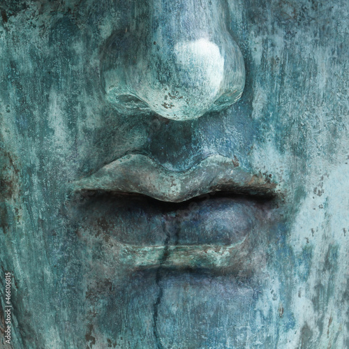 Human face made of rough stone. Bust of turquoise color close up
