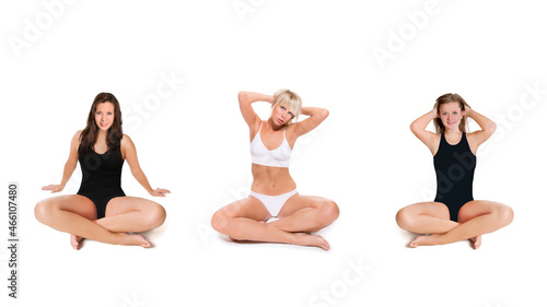 Three slim young women wearing white and black swimwear, isolated in front of white studio background 