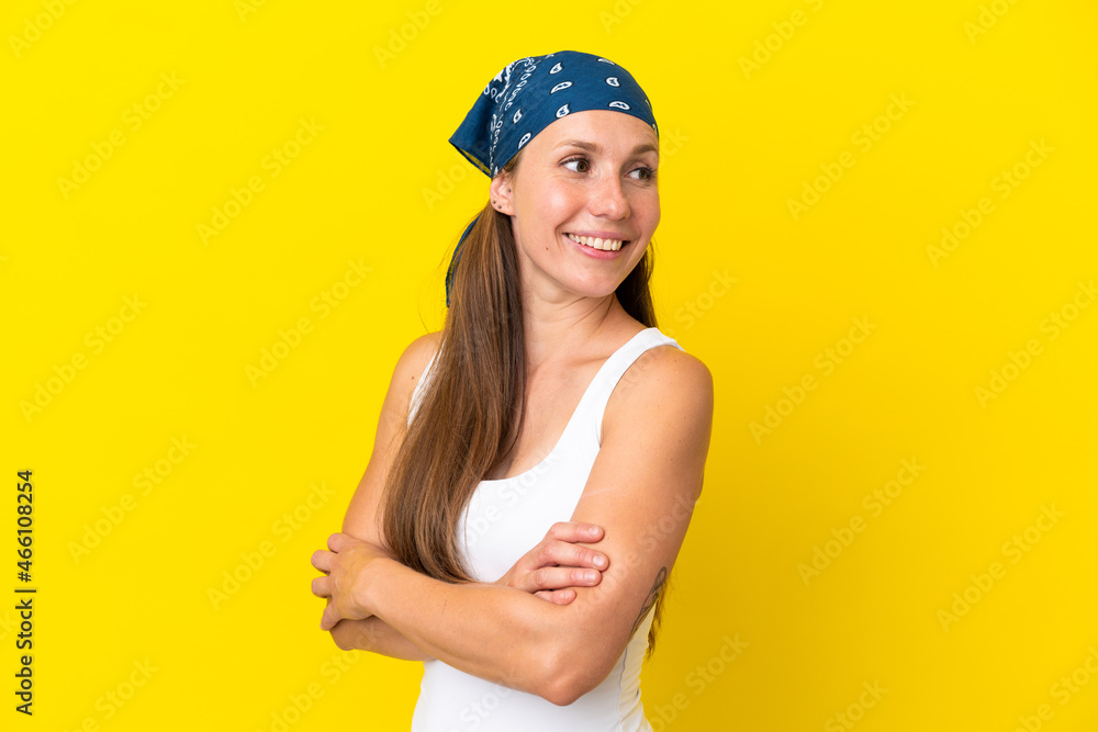 Young English woman isolated on yellow background with arms crossed and happy Young English woman isolated on yellow background with arms crossed and happy