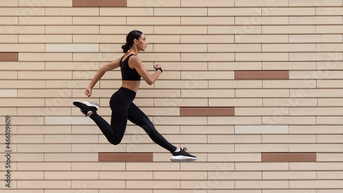 Active Lifestyle. Athletic Young Lady In Sportswear Running Over Brick Urban Wall