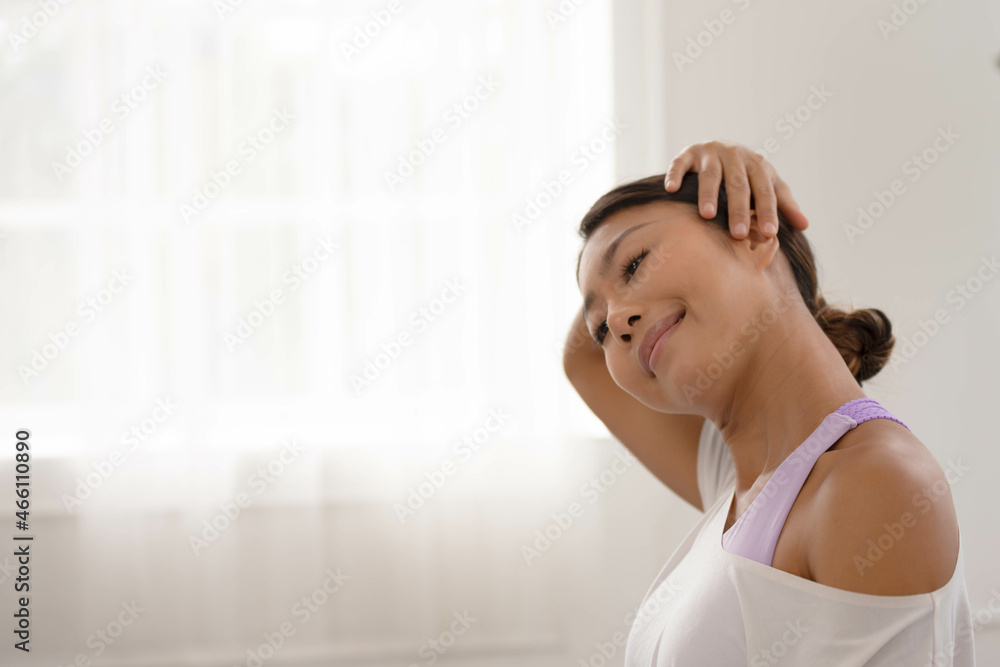 Asian woman exercises In the fitness studio, practice neck stretching and meditation for better health. Asian woman exercises In the fitness studio, practice neck stretching and meditation for better health.