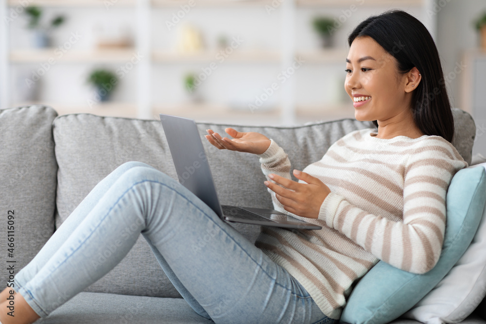 Positive Young Asian Female Using Laptop For Video Call At Home