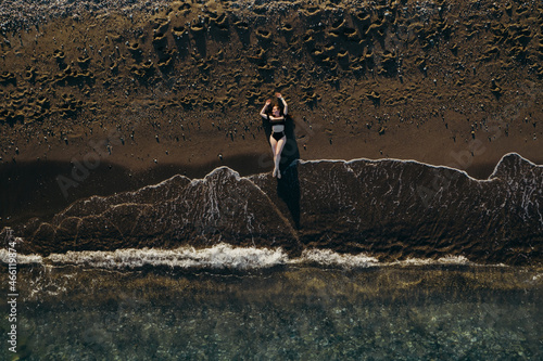 the girl is lying on the deck of the ship top viewand on the sand