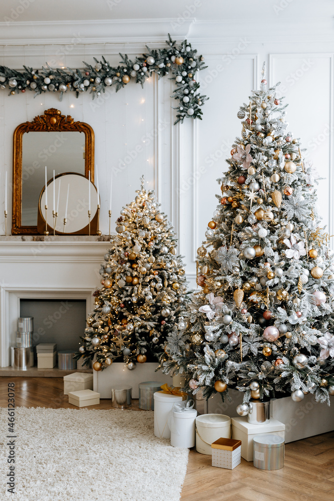 Obraz premium Beautiful Christmas tree with festive gold, white decor against blurred lights on background. Christmas and New Year concept. 