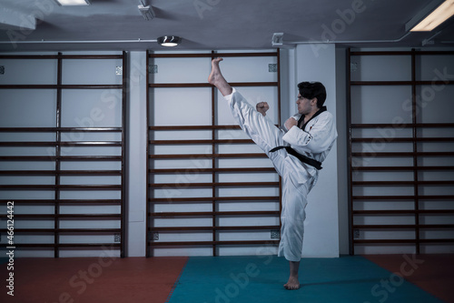 a taekwondo master kicking a tatami mat.