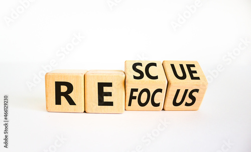 Refocus and rescue symbol. Businessman turned cubes and changed the word 'refocus' to 'rescue'. Beautiful white table, white background. Business refocus and rescue concept. Copy space.