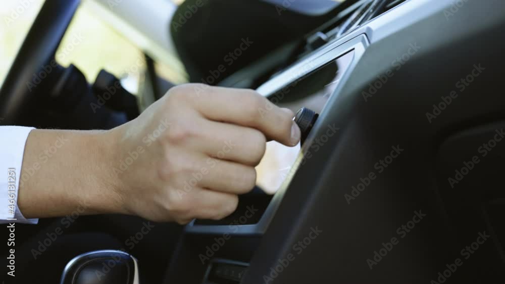 The driver turned to the radio. Adjusting volume of speaker with fingers to listen to music. Press the car audio button The driver turned to the radio. Adjusting volume of speaker with fingers to listen to music. Press the car audio button