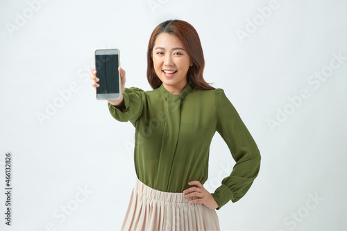 Portrait of beautiful Asian wowan showing or presenting mobile phone application on hand isolated over white background photo