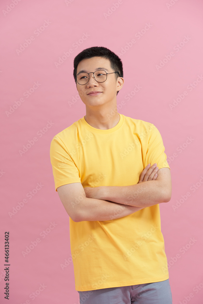 young man crossing arms over pink background young man crossing arms over pink background