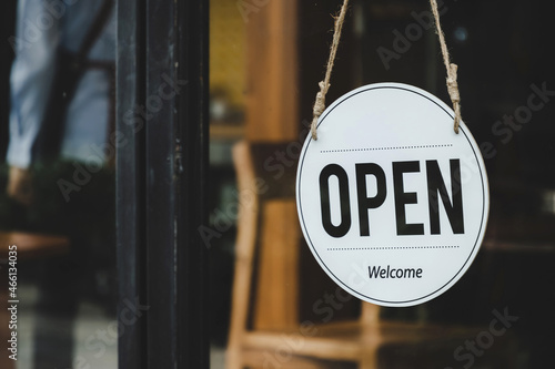 Welcome. vintage wooden OPEN sign board hanging on glass door in modern cafe restaurant, reopening cafe restaurant, retail store, small business owner, takeaway food, food and drink concept