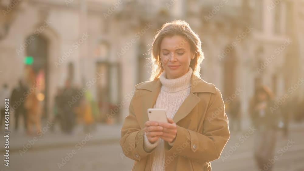 Portrait of attractive attractive senior woman texting on her phone. Beautiful young woman at the sunny city street. High quality 4k footage Portrait of attractive attractive senior woman texting on her phone. Beautiful young woman at the sunny city street. High quality 4k footage