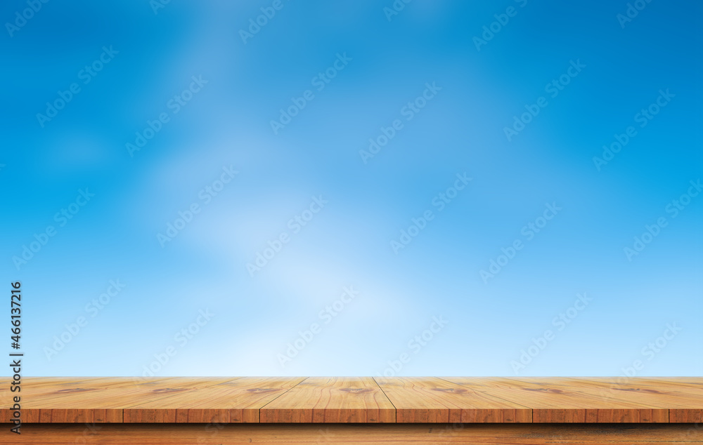 Wooden table with blue sky blurred background.
