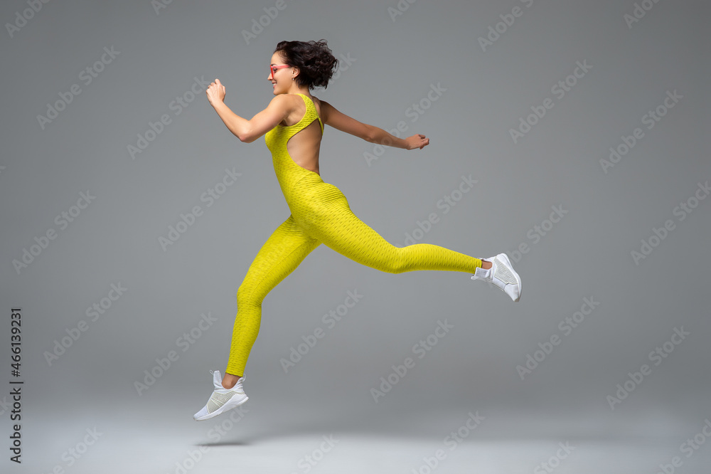Young sportswoman leaping and smiling