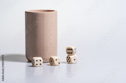 drewniane kości do gry i kubek na białym tle