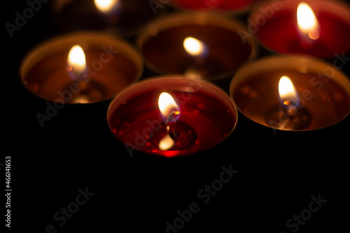 Candle flames in the dark. Candles burn with yellow fire. Liquid wax gradually melts.