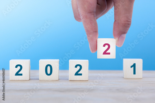 Male hand putting the wooden cube No.2 to change the 2021, concept New Year, New job, Start up again, Happy New Year 2022.